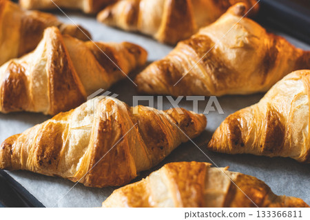 Top view on croissants on baker's paper on baking sheet. Top view on croissants on baker's paper on baking sheet. 133366811
