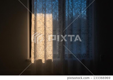 Winter light filtering through lace curtains and soft sunlight on a quiet window background 133366969