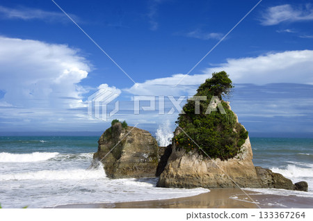 夏季的茨城縣日立市海岸。白色的海浪拍打著巨大的岩石，積雨雲在藍天的映襯下顯得格外壯觀美麗。 133367264