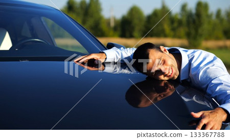 Successful smiling manager bought new electrical vehicle and hugging hood of auto. Happy young businessman in shirt enjoying modern electric automobile. Concept of buy or rent car. Slow motion Successful smiling manager bought new electrical vehicle and hugging hood of auto. Happy young businessman in shirt enjoying modern electric automobile. Concept of buy or rent car. Slow motion 133367788