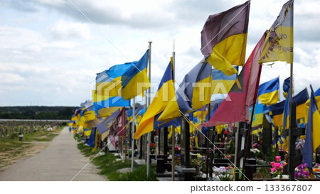 View on blue-yellow flags at countless graves of ukrainian soldiers alley of glory in Kharkiv. This site commemorates heroes and maintains the memory of wartime events in Ukraine. Slow moiton View on blue-yellow flags at countless graves of ukrainian soldiers alley of glory in Kharkiv. This site commemorates heroes and maintains the memory of wartime events in Ukraine. Slow moiton 133367807