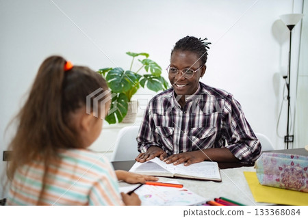 Child learns art techniques from an engaging mentor in a cozy space Child learns art techniques from an engaging mentor in a cozy space 133368084