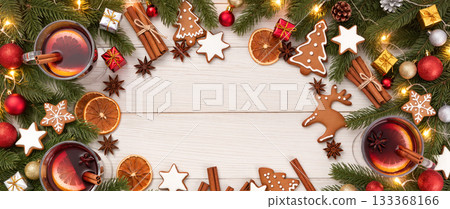 Christmas flat lay with gingerbread cookies, mulled wine, fir branches, and festive decorations on wooden table. Holiday background with copy space. 133368166
