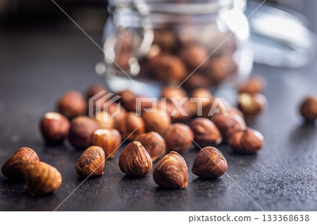 Peeled hazelnut kernels on black table. Peeled hazelnut kernels on black table. 133368638