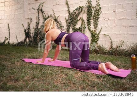 Mother engages in postpartum exercise outdoors to regain strength and confidence 133368945