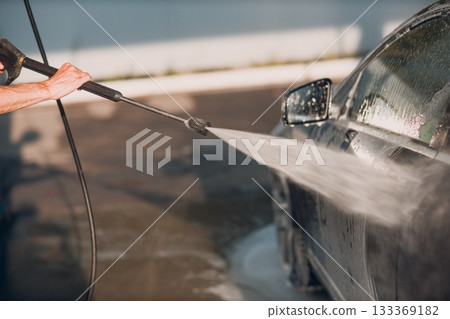 Worker washing car at self-service car wash 133369182
