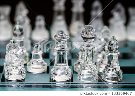 glass, transparent chess pieces on a checkerboard, selective focus, close-up, isolated on black glass, transparent chess pieces on a checkerboard, selective focus, close-up, isolated on black 133369407