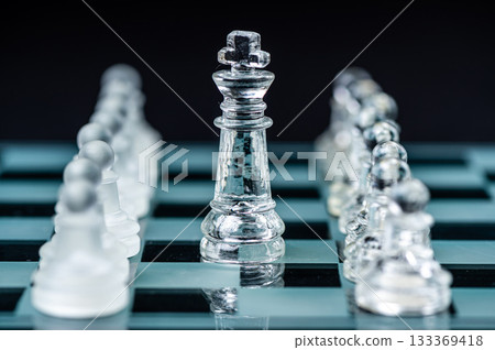 Transparent glass chess pieces on dark background. Leadership and strategy concept, selective focus Transparent glass chess pieces on dark background. Leadership and strategy concept, selective focus 133369418