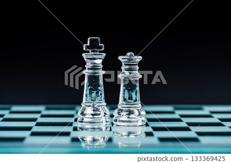 queen and king on the chess board, macro image of glass pieces. Shallow dof, selective focus queen and king on the chess board, macro image of glass pieces. Shallow dof, selective focus 133369425