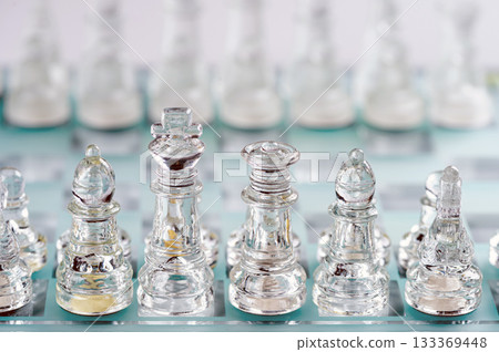 glass, transparent chess pieces on a checkerboard, selective focus, close-up, isolated on light glass, transparent chess pieces on a checkerboard, selective focus, close-up, isolated on light 133369448