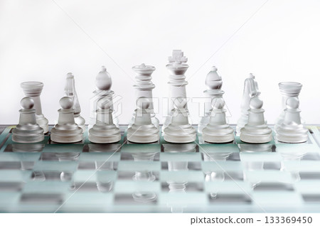 glass, transparent chess pieces on a checkerboard, selective focus, close-up, isolated on light glass, transparent chess pieces on a checkerboard, selective focus, close-up, isolated on light 133369450