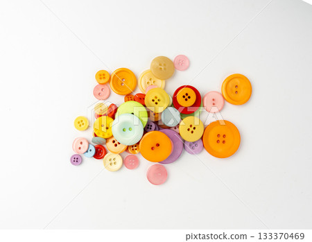 Multicolored sewing buttons isolated. Plastic sew buttons of different colors and sizes 133370469