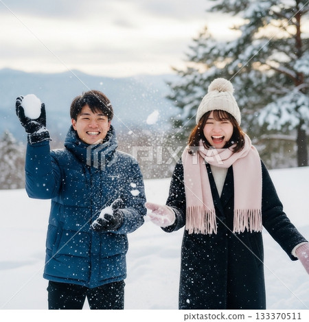 A young, friendly Japanese couple playing in the snow in a snowy place 133370511