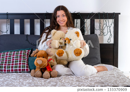 nice attractive woman sitting in bed hugging her soft childhood toys nice attractive woman sitting in bed hugging her soft childhood toys 133370909
