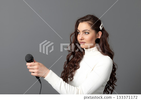 young female journalist with microphone isolated on gray background, isolated on gray 133371172