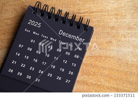 Top view of black December 2025 calendar on wooden cover background. Year end concept. Top view of black December 2025 calendar on wooden cover background. Year end concept. 133371511