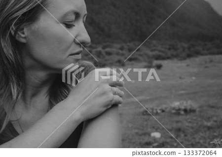 woman gently caressing her shoulder, serene scene of woman nurturing herself with gentle touch woman gently caressing her shoulder, serene scene of woman nurturing herself with gentle touch 133372064