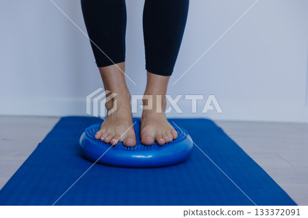 engaging core muscles through subtle microadjustments on inflatable cushion in peaceful exercise 133372091