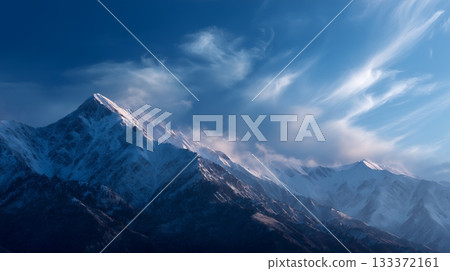 Majestic snow-capped mountains under a clear blue sky at twilight 133372161