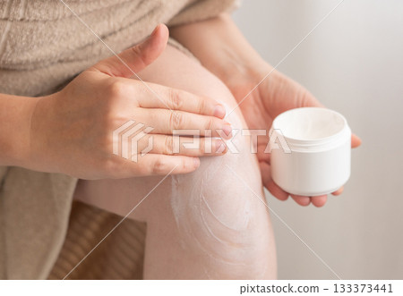 Cream on knee skin. Applying the lotion to dry rough legs skin, elbow moisturizing creme Cream on knee skin. Applying the lotion to dry rough legs skin, elbow moisturizing creme 133373441