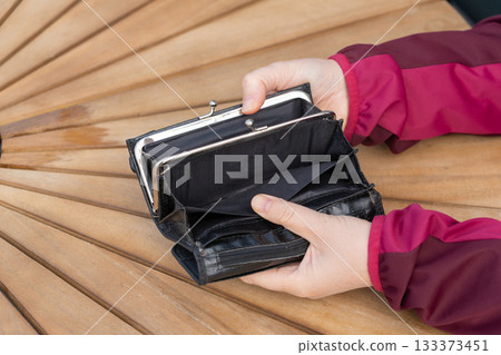Empty wallet in hands close-up. A black wallet with no money, poor person, economy crisis Empty wallet in hands close-up. A black wallet with no money, poor person, economy crisis 133373451