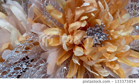 Warm orange flower macro with silver glitter accents. Contrast festive/autumn textile texture Warm orange flower macro with silver glitter accents. Contrast festive/autumn textile texture 133373854