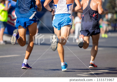Back view three athletes running marathon race in city 133373967
