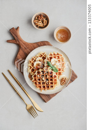 Homemade waffles with topping of honey, walnut and banana Homemade waffles with topping of honey, walnut and banana 133374005