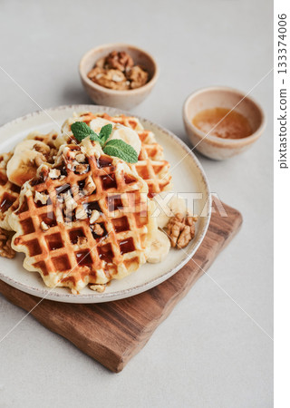 Homemade waffles with topping of honey, walnut and banana 133374006