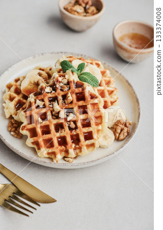 Homemade waffles with topping of honey, walnut and banana 133374008