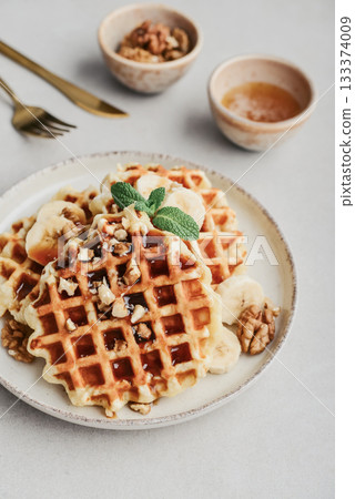 Homemade waffles with topping of honey, walnut and banana 133374009