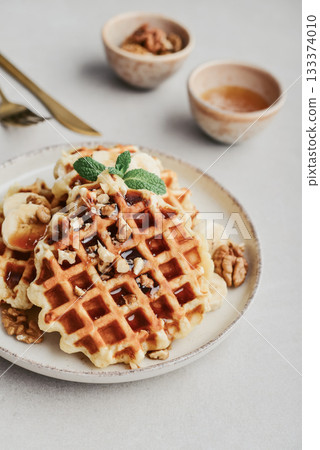 Homemade waffles with topping of honey, walnut and banana 133374010