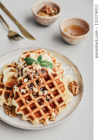 Homemade waffles with topping of honey, walnut and banana 133374011
