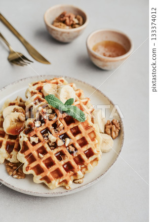 Homemade waffles with topping of honey, walnut and banana 133374012