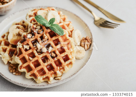 Homemade waffles with topping of honey, walnut and banana Homemade waffles with topping of honey, walnut and banana 133374015