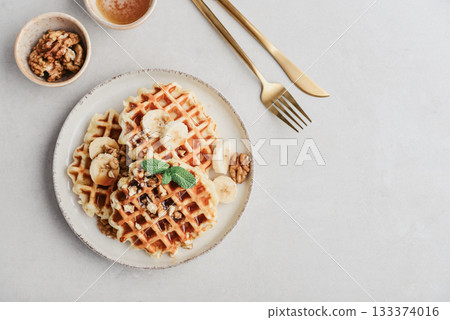 Homemade waffles with topping of honey, walnut and banana Homemade waffles with topping of honey, walnut and banana 133374016