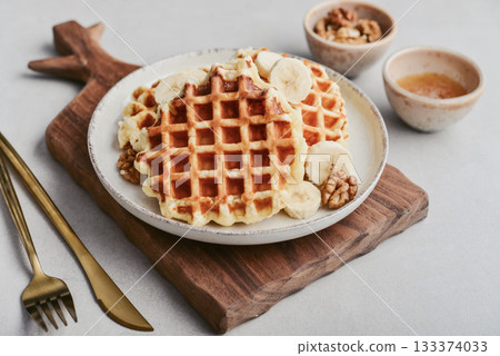 Homemade waffles with topping of honey, walnut and banana 133374033