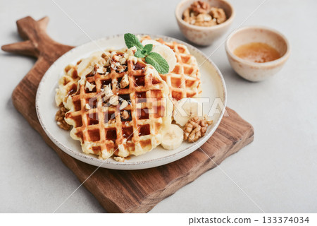 Homemade waffles with topping of honey, walnut and banana 133374034
