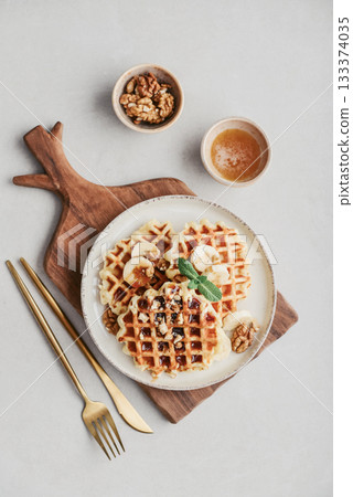 Homemade waffles with topping of honey, walnut and banana 133374035