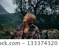enthusiastic woman with open smile feels rejuvenated during grounding walk amidst green trees 133374320