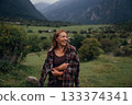 hopeful female hiker amidst panoramic scenery, panoramic valley scene with reflective adventurous 133374341