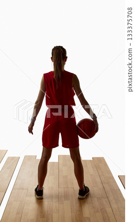 Female basketball player standing with ball in calm determined stance 133375708