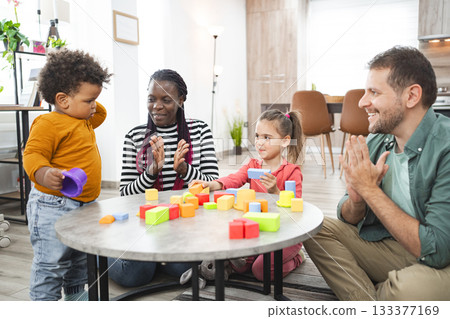 Multiracial family playtime with colorful blocks in a cozy living room Multiracial family playtime with colorful blocks in a cozy living room 133377169