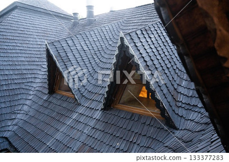shingles on the roof. Wooden roof, shingled roof. Wooden tile. Roof of complex construction with dormer windows 133377283