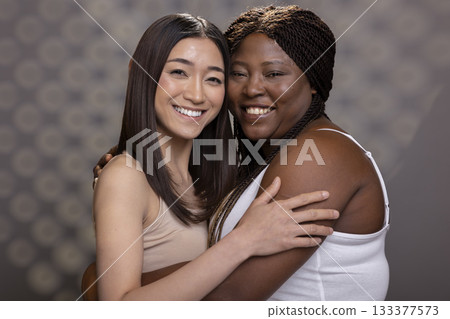 Beautiful women with different skin tones and body types posing in the studio, showing self love and empowerment with radiant glowing skin. Portrait highlighting soft femininity. Beautiful women with different skin tones and body types posing in the studio, showing self love and empowerment with radiant glowing skin. Portrait highlighting soft femininity. 133377573