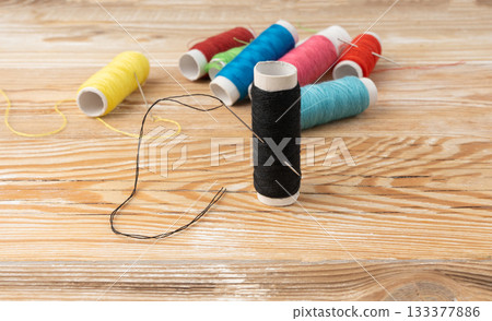 Needle and thread. Needlework object, color cotton thread spool and needle Needle and thread. Needlework object, color cotton thread spool and needle 133377886