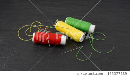 Needle and thread. Needlework object, color cotton thread spool and needle Needle and thread. Needlework object, color cotton thread spool and needle 133377889