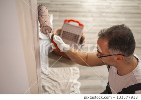 Man Painting Wall With Paint Roller 133377918
