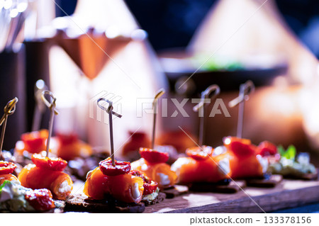 Pumpernickel bread sandwich snack with cured smoked salmon and fresh avocado served as close-up on a wooden cutting board 133378156