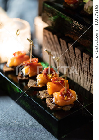 Pumpernickel bread sandwich snack with cured smoked salmon and fresh avocado served as close-up on a wooden cutting board Pumpernickel bread sandwich snack with cured smoked salmon and fresh avocado served as close-up on a wooden cutting board 133378165
